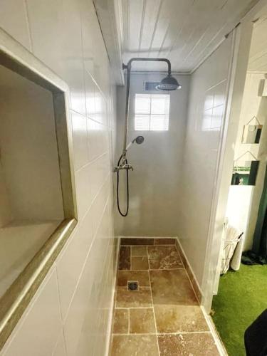 La salle de bains est pourvue d'une douche et de carrelage. dans l'établissement Maison Damour, à Longeves