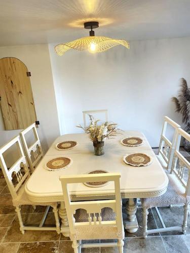 une table à manger avec des chaises et un plafond jaune dans l'établissement Maison Damour, à Longeves