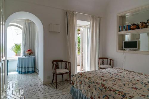 1 dormitorio con cama, mesa y ventana en Beautiful Villa with View in the heart of Capri, en Capri