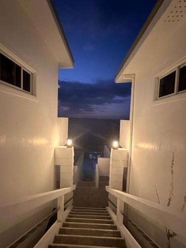 a stairway leading to a balcony at night at CasaDel Beach House in Mabini