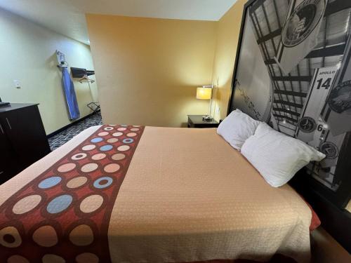 a large bed in a hotel room with a large bedspread at Super 8 by Wyndham Pasadena in Pasadena