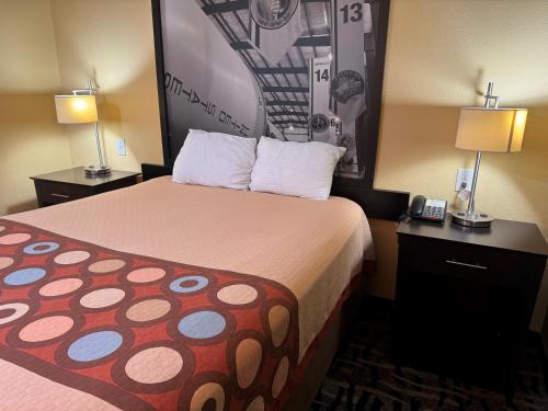 a hotel room with a large bed with two lamps at Super 8 by Wyndham Pasadena in Pasadena
