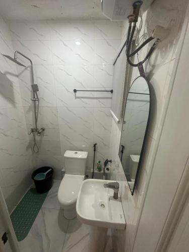 Baño blanco con lavabo y espejo en Deemich Maison 2bed apartment. en Lagos