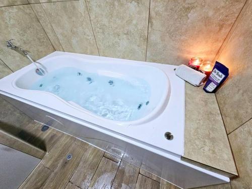 La salle de bains est pourvue d'une baignoire avec deux bougies. dans l'établissement Casa de Playa Luxury Laguna Azul Tacna, à Tacna
