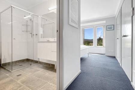 baño blanco grande con ducha y bañera en 3-Bed with Alfresco Dining & Pool in Batemans Bay, en Batemans Bay
