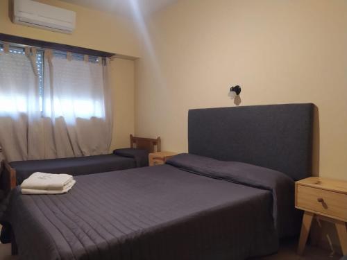 ein Schlafzimmer mit einem Bett, einem Stuhl und einem Fenster in der Unterkunft Hotel Manzanares Plaza in Buenos Aires