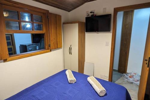 a bedroom with a blue bed and a window at Casa histórica do escravo isidoro in Diamantina