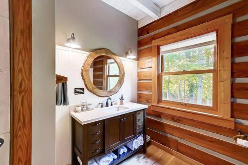 ein Bad mit einem Waschbecken und einem Spiegel in der Unterkunft Large Log Cabin Chalet w/ Hot Tub - Horses & Lake! in Loveland