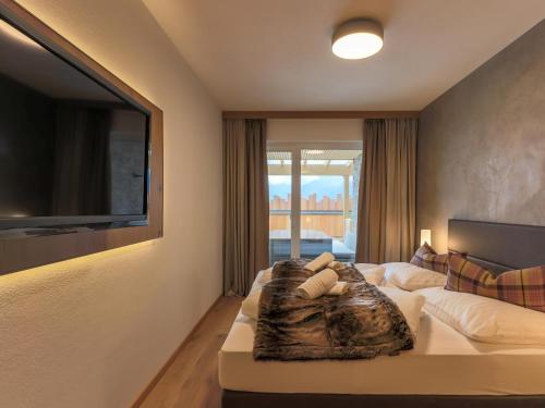 um quarto com uma cama e uma televisão na parede em Kitzbüheler Alpenlodge Top A2 em Mittersill