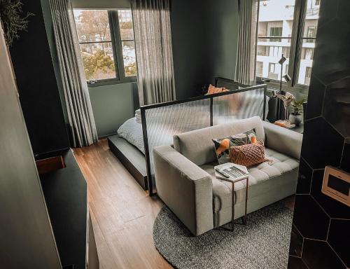 sala de estar con sofá y silla en The Green Rooms - Luxury themed micro apartments inspired by tiny home design, en Canberra