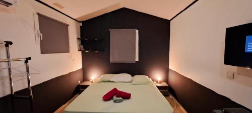 Cette petite chambre comprend un lit avec des gants rouges. dans l'établissement Le Paradis des Petits Voyageurs - Maison d'Hôtes comprenant 1 Chambre et 1 Tente à 2km de la plage O'Mullane bas au Diamant, au Diamant