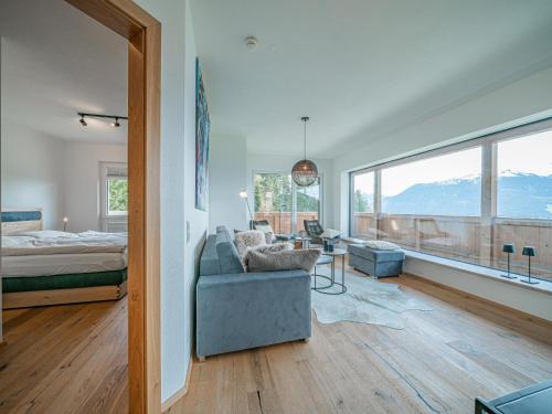 sala de estar con sofá, cama y ventanas en Kitzbüheler Alpenlodge Top A8 en Mittersill
