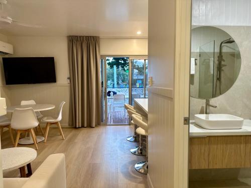 a bathroom with a sink and a table with chairs at Lake Tinaroo Holiday Park in Tinaroo