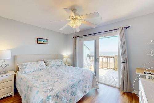 a bedroom with a bed and a ceiling fan at Three Sea in Carolina Beach