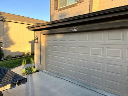 a garage door of a house with a driveway at Cheerful 3 bd home with easy access to interstate! in Omaha
