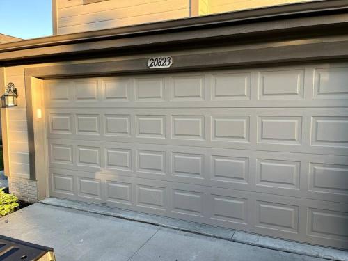 a garage door with a sign on it at Cheerful 3 bd home with easy access to interstate! in Omaha