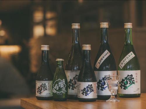 a group of four bottles of wine sitting on a table at Chalet Shiga in Yamanouchi