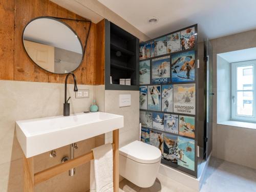 La salle de bains est pourvue d'un lavabo, d'un miroir et de toilettes. dans l'établissement Biber Art Chalet, à Biberwier