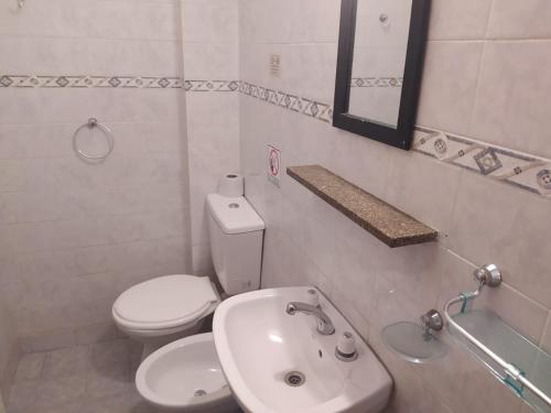 Baño blanco con aseo y lavamanos en Hotel Manzanares Plaza en Buenos Aires