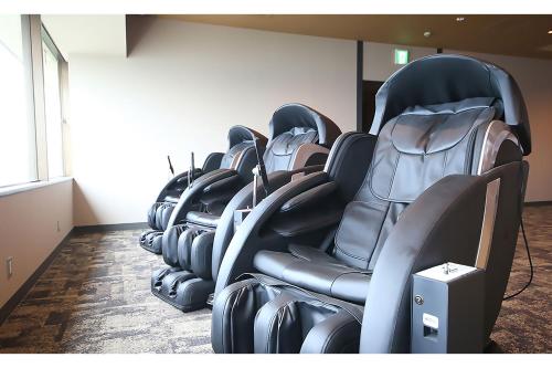 a row of black chairs in a room at Ooedo Onsen Monogatari Beppu Seifu in Beppu