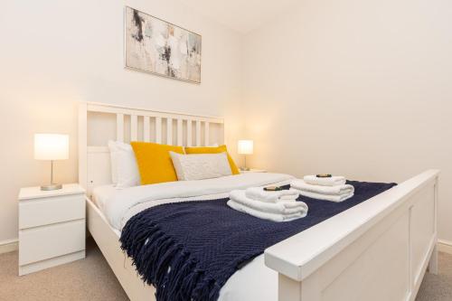 a bedroom with a white bed with towels on it at Hidden Gem 2BR flat wBalcony near Surrey Quays in London