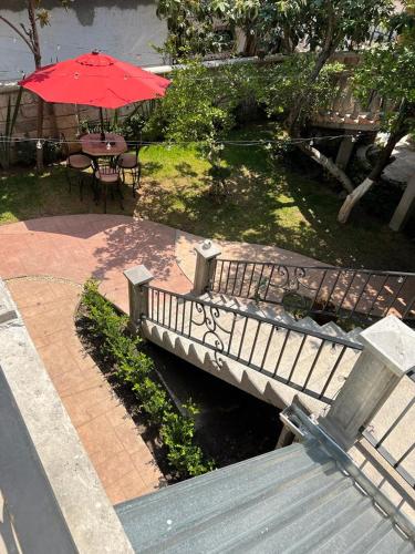 a bridge with a table and a red umbrella at Departamento cómodo y céntrico en Malinalco. in Malinalco