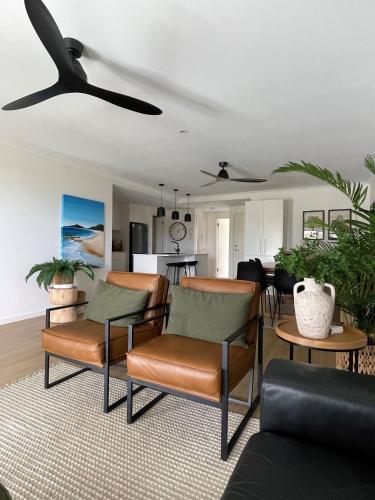 a living room with chairs and a ceiling fan at Jubilee Apartment 05 - Bring your own linen in South West Rocks