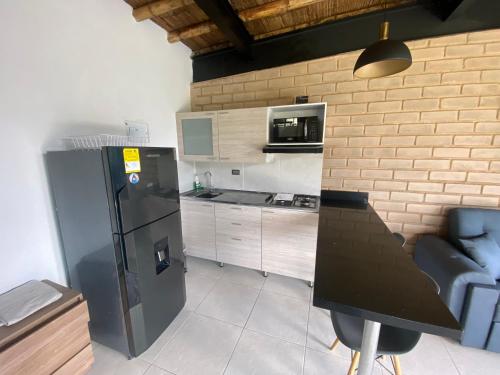 a kitchen with a black refrigerator and a counter at Springfield Ecoloft- Guatapé in Guatapé