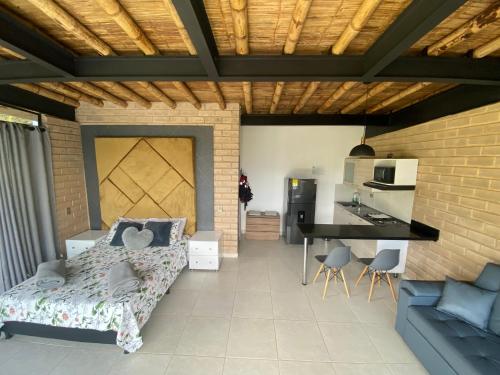 a living room with a bed and a kitchen at Springfield Ecoloft- Guatapé in Guatapé