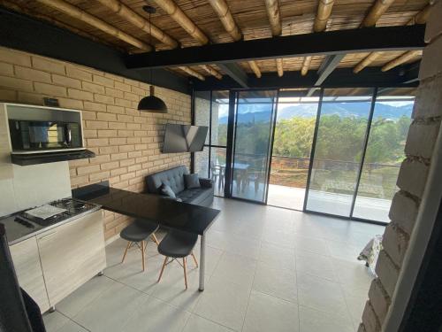 a kitchen with a table and chairs in a room at Springfield Ecoloft- Guatapé in Guatapé