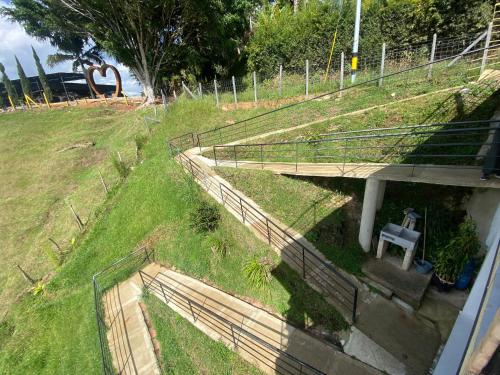 a bridge over a grassy hill with a bench at Springfield Ecoloft- Guatapé in Guatapé