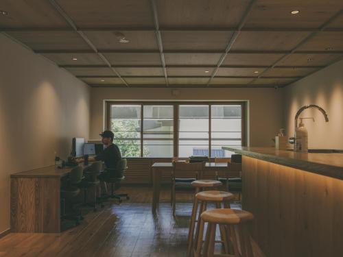 a man sitting at a bar in a restaurant at Chalet Shiga in Yamanouchi
