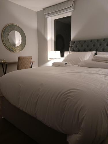 una camera da letto con un grande letto bianco e uno specchio di Wood View Cottage 