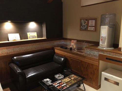 a waiting area with a leather seat in a restaurant at HOTEL Sweets in Mobara