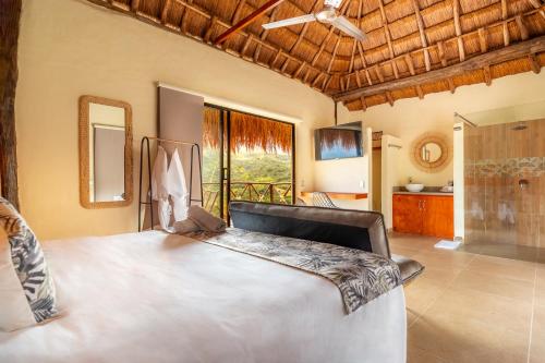 a bedroom with a large bed and a large window at Hotel Alto de Pajas Boutique by H&R in Villeta