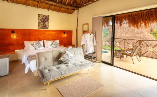 a living room with a couch and a bed at Hotel Alto de Pajas Boutique by H&R in Villeta