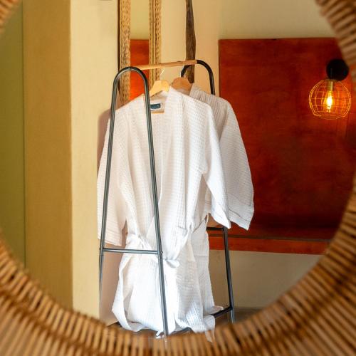 a white shirt hanging on a rack in a room at Hotel Alto de Pajas Boutique by H&R in Villeta