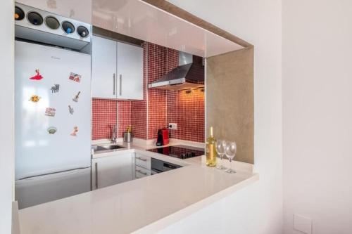 a kitchen with white cabinets and a white counter top at Torremolinos Carihuela El Bulto sun&beach Eurosol apartament in Torremolinos