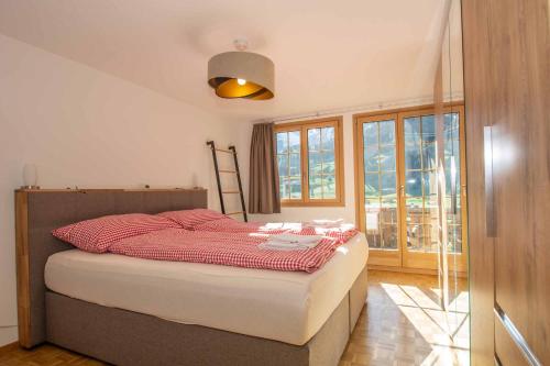 um quarto com uma cama com um cobertor vermelho em Am Strubelweg em Adelboden