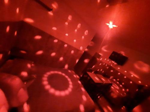 ein dunkles Zimmer mit roten Lichtern und einem Stuhl in der Unterkunft HOSTAL LARA in Arequipa