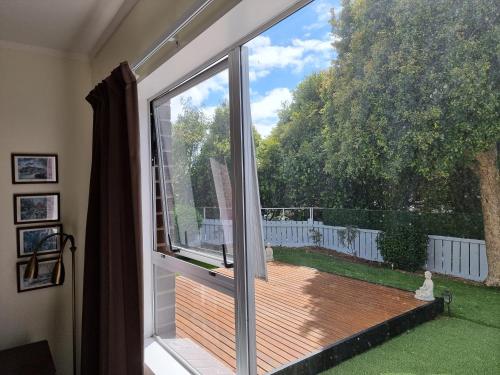 an open window with a view of a deck at Entire ground floor with full-privacy and family-friendly popular to ferry catchers in Wellington
