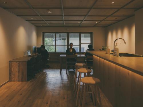 a group of people sitting at a bar in a restaurant at Chalet Shiga in Yamanouchi