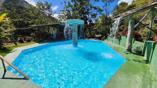a pool with a water fountain in a yard at Hospedajes Richie Eco Camp in Providencia