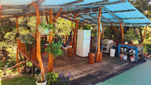 a wooden pergola with a refrigerator on a deck at Hospedajes Richie Eco Camp in Providencia
