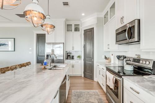 a kitchen with white cabinets and a counter top at Footprints in the Sand - Luxe Freeport Home! in Freeport