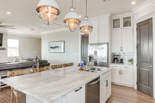 a kitchen with white cabinets and a large counter top at Footprints in the Sand - Luxe Freeport Home! in Freeport
