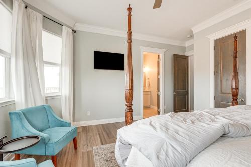 a bedroom with a bed and a blue chair at Footprints in the Sand - Luxe Freeport Home! in Freeport
