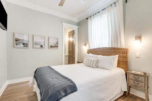 a bedroom with a white bed and a window at Footprints in the Sand - Luxe Freeport Home! in Freeport