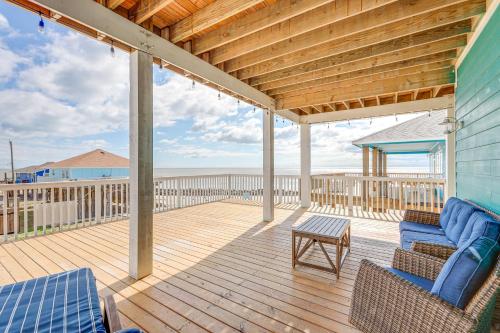 a covered deck with two chairs and a table at Footprints in the Sand - Luxe Freeport Home! in Freeport