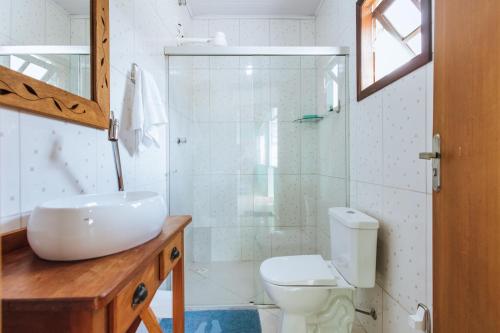 een badkamer met een wastafel, een toilet en een douche bij pousada formibela in Ilhabela